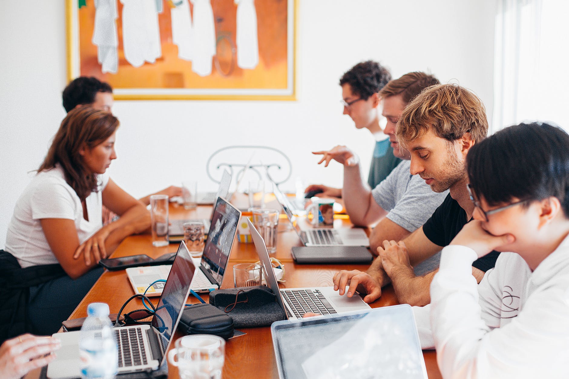 A group of people sitting around a table and working on their laptops. The rise of the knowledge worker and personal productivity.